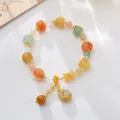 Detail of colorful pumpkin-shaped jade beads and safety buckle pendant on woven bracelet - Pumpkin Beads With Golden Silk Jade Safety Buckle