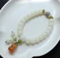 Natuurlijke Bodhi kralenarmband met groene tussenstukjes en een oranje kalebas hanger - Chalcedoon Fleskalebas Stijl