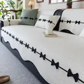 Copridivano in ciniglia bianco sporco con bordi ondulati e decorazioni a fiocco nero - 70*70cm / Bianco