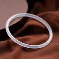 Detailed macro view of a slender white chalcedony agate bangle with a smooth polished finish - Plain White