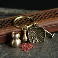 Macro shot of vintage brass keychain set with mini gourd, bell, shovel and broom charms - Small Hollow Brass Gourd with Dustpan and Ring (HTYS18)