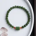 Dettaglio macro di bracciale in diaspro verde con perla cilindrica su piatto bianco - Perla a Barile di Diaspro