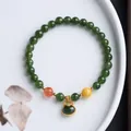 Macro scatto di bracciale in diaspro verde con agata rossa e ciondolo a lucchetto d'oro - Borsa di Diaspro