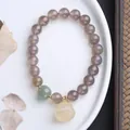 Detalle de pulsera de ágata gris con colgante de loto de jade y toques dorados - Ágata Gris Loto