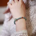 Blue jadeite abacus bead bracelet with green jade donut and red agate on a wrist - Blue Water Jadeite Abacus Bead Running Ring Style