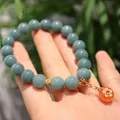 Blue jade and Yanyuan agate bracelet with gold flower charm on a model's wrist - Blue Water Jadeite Yanyuan Agate Safety Buckle Flower Style