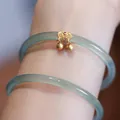 Brazalete de calcedonia celadón con colgante de campana Ruyi dorada en muñeca - Par Azul Celeste Calado Ruyi Campana