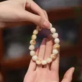 Macro detail of bodhi root bracelet with carved cat paw beads and creamy white finish - Charred Cat Paw Style / 12mm Pearl