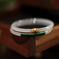 Primer plano de brazaletes de calcedonia con Ruyi dorado y detalles de hilo verde - Estilo Ruyi de Calcedonia Blanca Envuelto en Alambre / Blanco