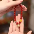 Handcrafted 8mm red agate beaded bracelet with golden auspicious bell charm on hand - Red Agate Tiger Head Bell Treasure Style / 8mm / Red