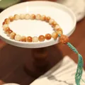 Detail of candy-colored Bodhi beads with red carved bead and long mixed tassels - Burnt Bodhi (Pixiu Pendant)