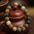 Traditionele veelkleurige Bodhi-zaad gebedskralen gewikkeld om een bruine theepot - Dunhuang Gradiënt Vatkraal