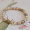 Handmade wooden bead bracelet with a white ceramic cat paw charm and natural texture - Wood / Milk Wood Charred Cat Paw Bracelet