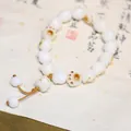 White jade bodhi seed bracelet featuring a cat paw charm and hand-woven brown cord - Charred Cat Paw Maneki-neko Style