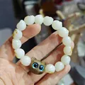 Cat paw white jade bodhi bracelet featuring a dark wooden cat head with blue eyes - Green Sandalwood / Verawood Kitten Style