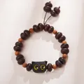 Macro view of ebony wood bracelet featuring a hand-carved black cat and round beads - Ebony / Purple Gold Bowl Ebony Kitten Style