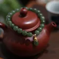 Natural dark green jade bead bracelet with gold hollow lotus pendant on teapot lid - Magnolia Style