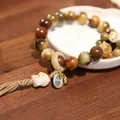 Brown bodhi seed bead bracelet with rabbit charm and peace tag on wooden desk - Coffee Spotted (Bear)