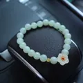 Natural light green jade bead bracelet featuring a white lotus charm and golden coin detail - Hetian Jade White Jade Plum Blossom