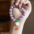 Macro shot of purple glass bead bracelet with white lion pendant on person wrist - Twilight Purple Lion Dance Glazed Glass Bracelet (Imitation Ivory Fruit)