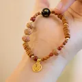 Primer plano de pulsera de semillas de Bodhi con cuarzo ahumado y colgante Fu dorado - Pulsera Rudraksha de Hueso de Oliva con Amuleto Fu / Mantra de Seis Palabras de Ágata Negra (MNSL16-01)