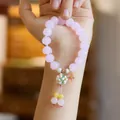 Pastel pink beaded bracelet with floral charms and tassel in a sweet Oriental style - Rouge Snow Pink Glazed Glass Flower Ball Bracelet