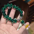 Ethnic style dark green fluted glass bead bracelet with purple floral accents - Twilight Forest Green Glazed Glass Lotus Bracelet