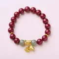 Pulsera de cuentas de cinabrio rojo con dijes de loto dorados sobre fondo rosa - Rojo / Large Bead Size