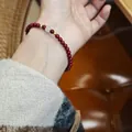 Pulsera de cinabrio natural con plata y jade Hetian en la muñeca de una mujer - Estilo Jade Hetian / Cuentas de Cinabrio 4mm