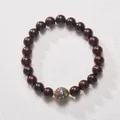 Macro shot of sandalwood beads with colorful lacquer bead and golden spacers - Green Lacquer Bead Sandalwood
