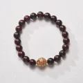 Macro shot of sandalwood beads with ornate cloud pattern centerpiece and gold spacers - White Lacquer Bead Sandalwood
