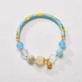 Detail of beaded bracelet with blue floral enamel, gemstone beads, and gold bell charm - Blue Heart of the Ocean Style