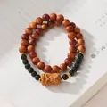 Macro d'un bracelet en bois de thuya avec tête de dieu sculptée et accents de jade - Jade de Hetian (Thuya Vieilli)