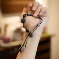 Detailed shot of handmade woven bracelet with obsidian beads and a carved lion charm - Fluorite Lion Braided Rope Bracelet Women
