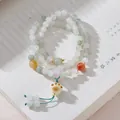 Three-wrap natural gold silk jade bracelet with cat claw charm and silk tassel details - Tianshan Jade Cat Paw Tassel