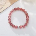 Macro shot of natural pink strawberry quartz beads and sparkling silver charm on white base - Strawberry Crystal White Zirconia Style