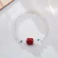 Detail of white jade beads bracelet with red cinnabar bead and small green spacers - Small Bead Style