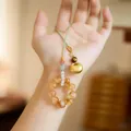 Natural yellow quartz crystal beads with a golden lucky charm on a green braided cord - Lucky Lock Style