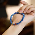 Natural 6mm blue kyanite beaded bracelet on wrist with gold accent and red bead detail - Guanshan Xiaoyue (Kyanite + S925 Silver Lucky Bead)