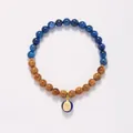 Handcrafted bracelet with blue gemstones, tiger eye beads and gold Buddha pendant - Chunjin (Kyanite + Kuku Bodhi + Carved Charm)