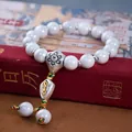 Detail of beaded bracelet with white porcelain beads and silver dorje vajra pendant - Gray Vajra Pestle