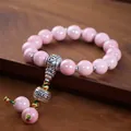 Pink glazed ceramic bead bracelet with silver vajra pestle and bell tassel detail - Pink Six-Syllable Mantra