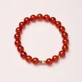 Natural red agate bracelet with colorful enamel bead and gold accents on pink background - 8mm / Red Agate Koi Style