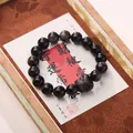 Black obsidian bead bracelet with carved Pixiu charm on a vintage gift card - 12mm Silver Obsidian Lion Bracelet