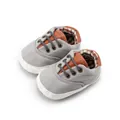 Detail of baby canvas shoes showing soft sole, checkered lining, and brown leather accents - Light Gray