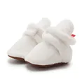 Macro shot of fluffy cream baby fleece boots with soft brown anti-slip soles - 13cm / White
