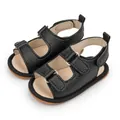 Detail view of black PU leather baby sandals with double velcro straps and non-slip soles - 11cm (0-6 Months) / Black
