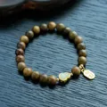 Detailed macro shot of sandalwood beads with jade gourd and gold luck charms - 8mm / Green Sandalwood & Hetian Jade Gourd Blessing