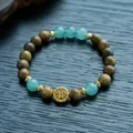 Detailed macro view of green sandalwood beads with jade gourd and gold metal charms - 8mm / Green Sandalwood & Yellow Wealth God