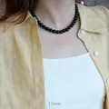 Detail of 10mm natural black agate beads necklace worn on a casual linen shirt - 10mm Black